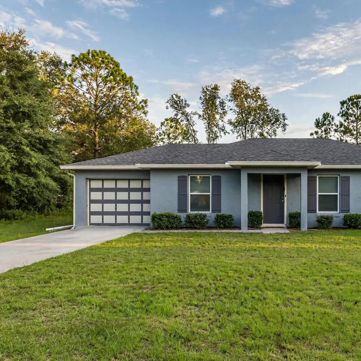 Single-story rental home with a garage, driveway and front lawn